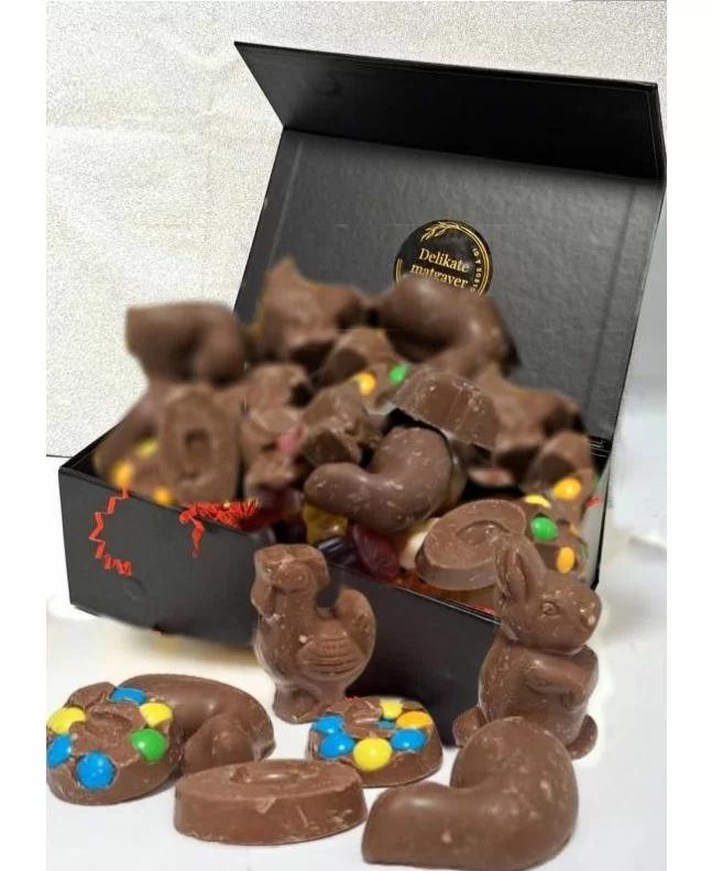 Bildet viser en elegant, sort firkantet magnet eske, fylt med løskvekt, sjokolade og godteri. Esken er ment for å erstatte den tradisjonelle påskeegget.