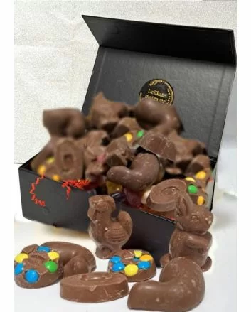 Bildet viser en elegant, sort firkantet magnet eske, fylt med løskvekt, sjokolade og godteri. Esken er ment for å erstatte den tradisjonelle påskeegget.